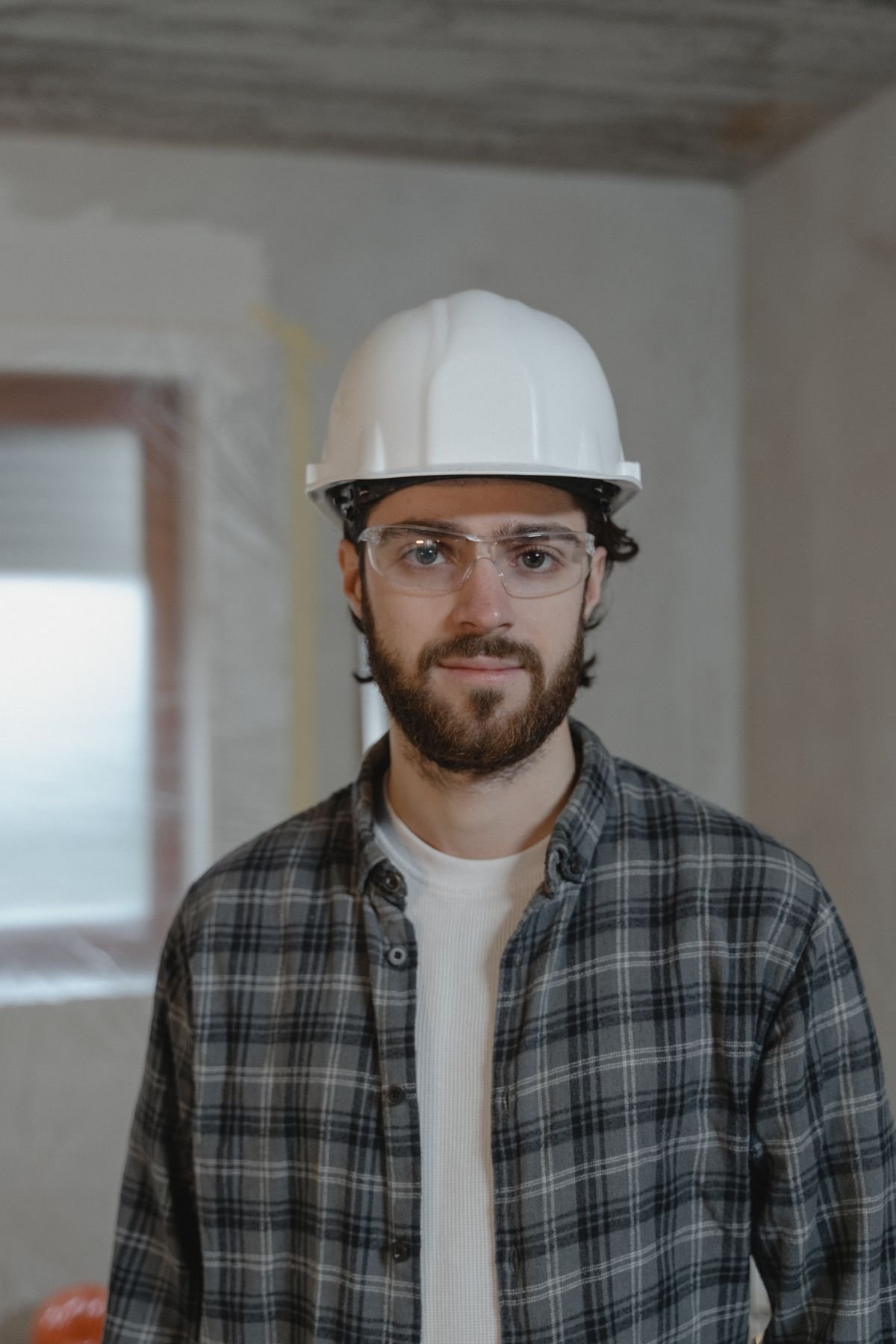 A construction worker wearing a hard hat and safety glasses